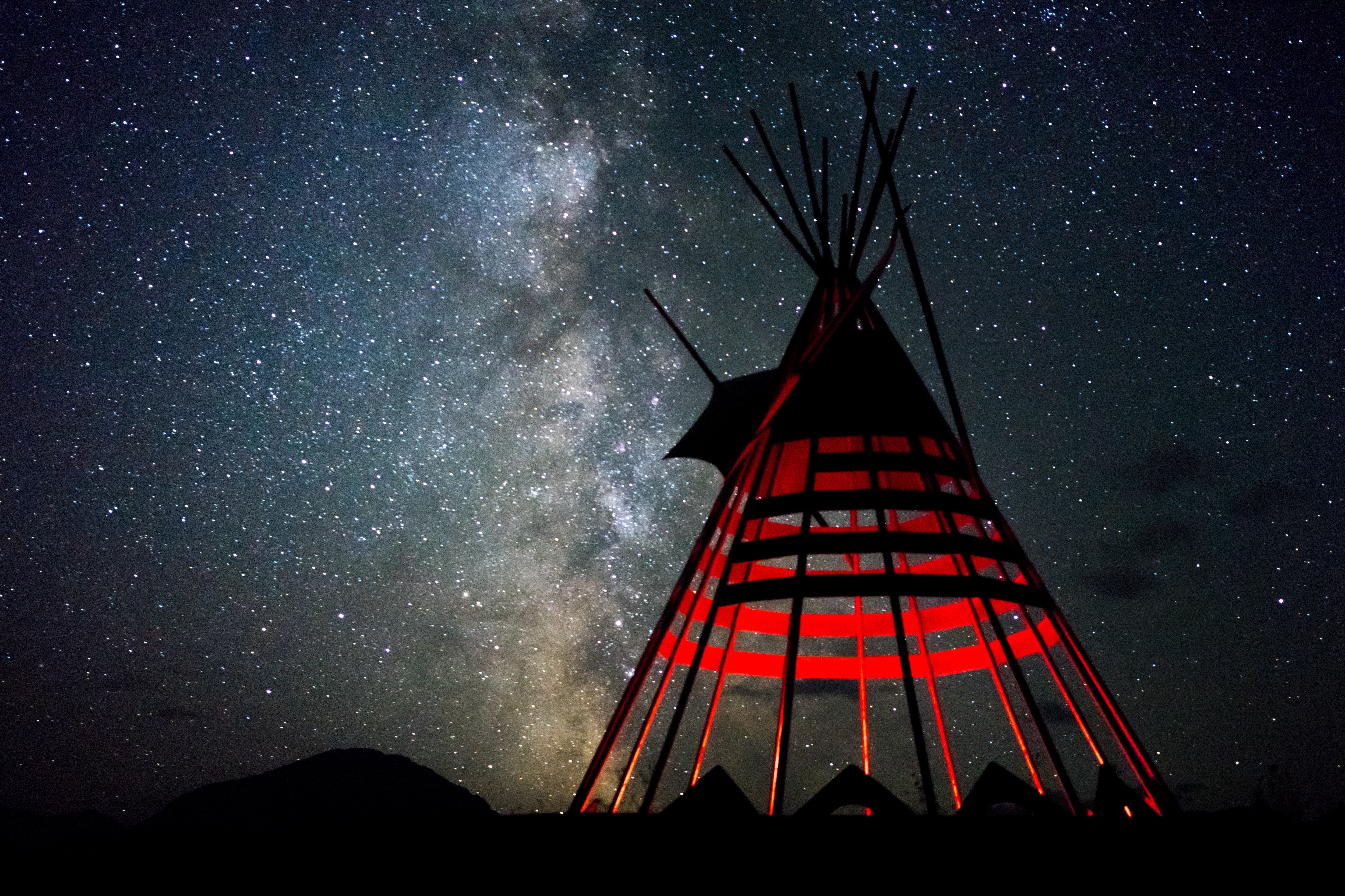 Photo by Sergei A: https://www.pexels.com/photo/red-and-black-indian-hut-under-star-sky-2539465/